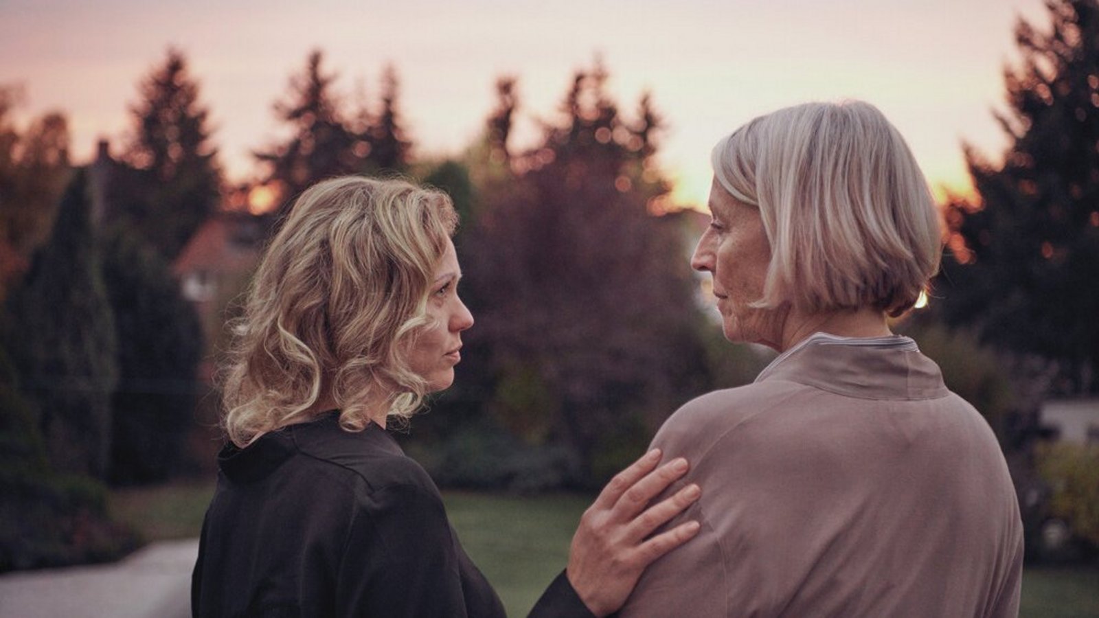 Zwei bedrückt wirkende Frauen draußen im Garten – Symbolbild für Depression