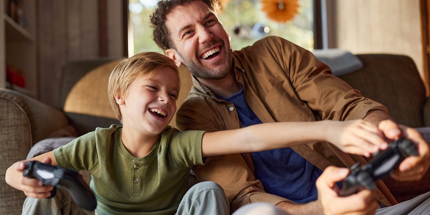 Sohn und Vater beim Videospielen.