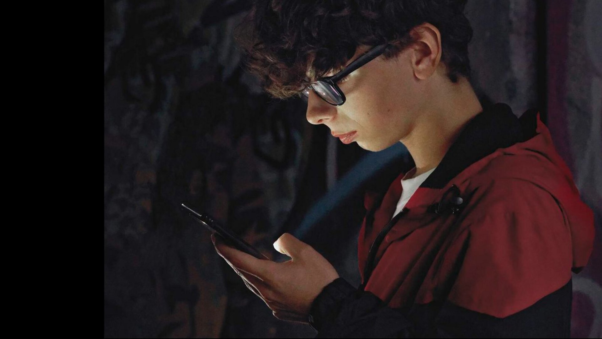 Junge schaut in sein Handy.