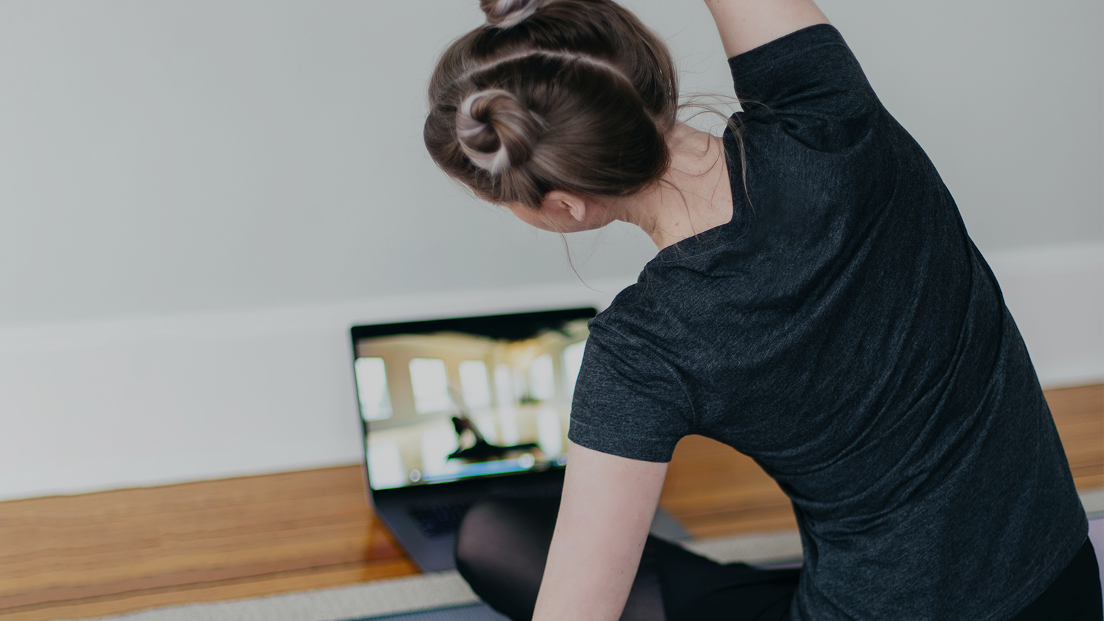 Eine junge Frau nimmt an einem Online-Yoga-Kurs teil