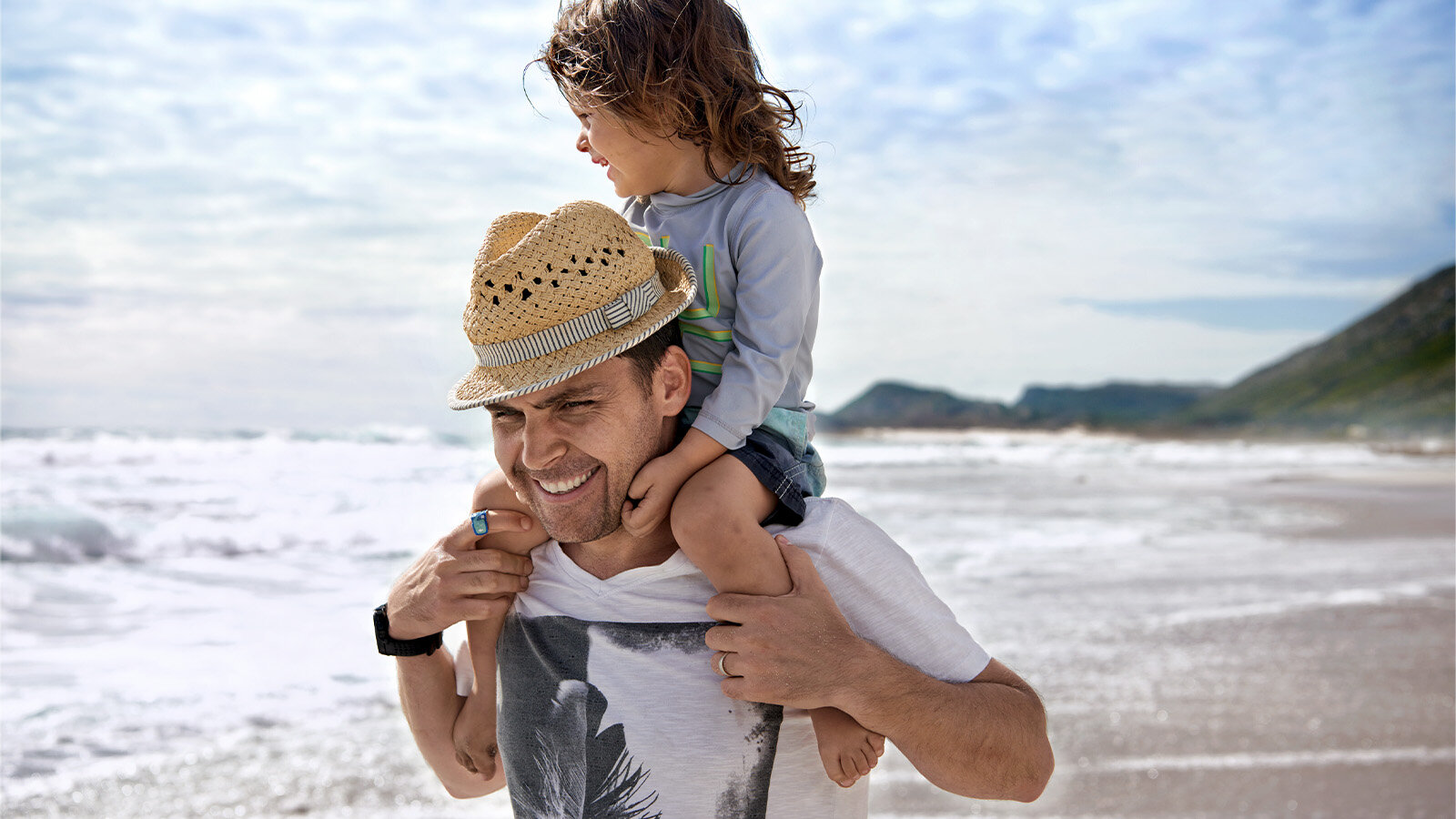 Mann mit Kind am Strand 