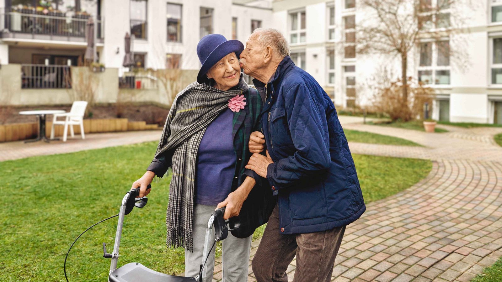 Ältere Frau mit Rollator wird liebevoll gestützt – Symbolbild für Pflege