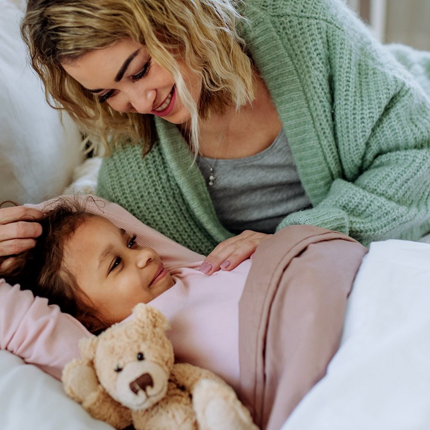 Mutter mit kleiner Tochter im Bett