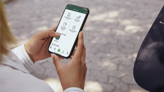 ​​Frauenhände halten ein Handy auf dem die App Meine AOK geöffnet ist.
