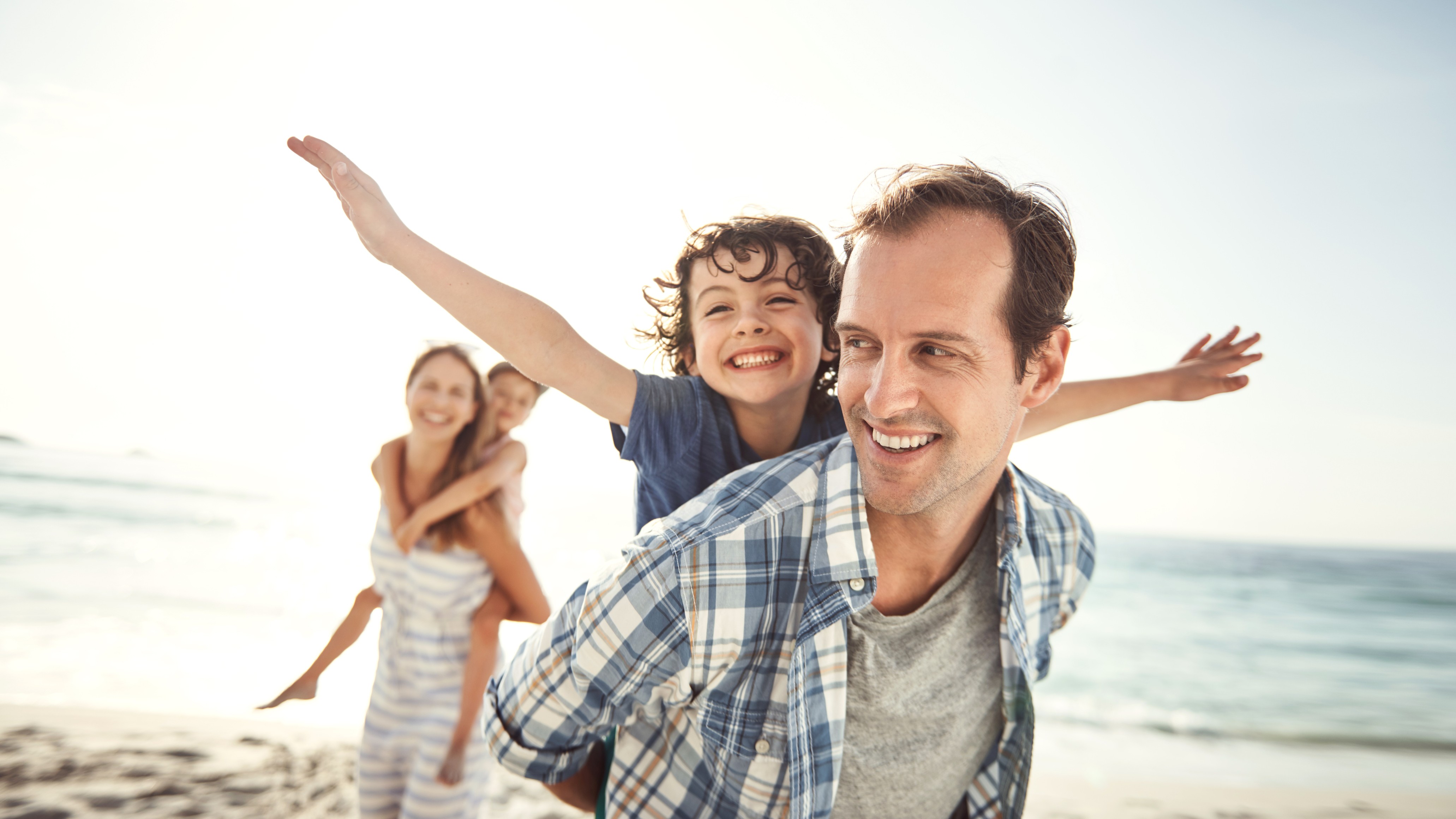 ​Familie (Eltern / zwei Kinder) haben Spaß im Sommer am Strand

iStock-637225048_shapecharge