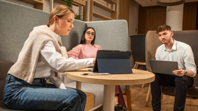 Drei Personen am Laptop in Rechercheposition.