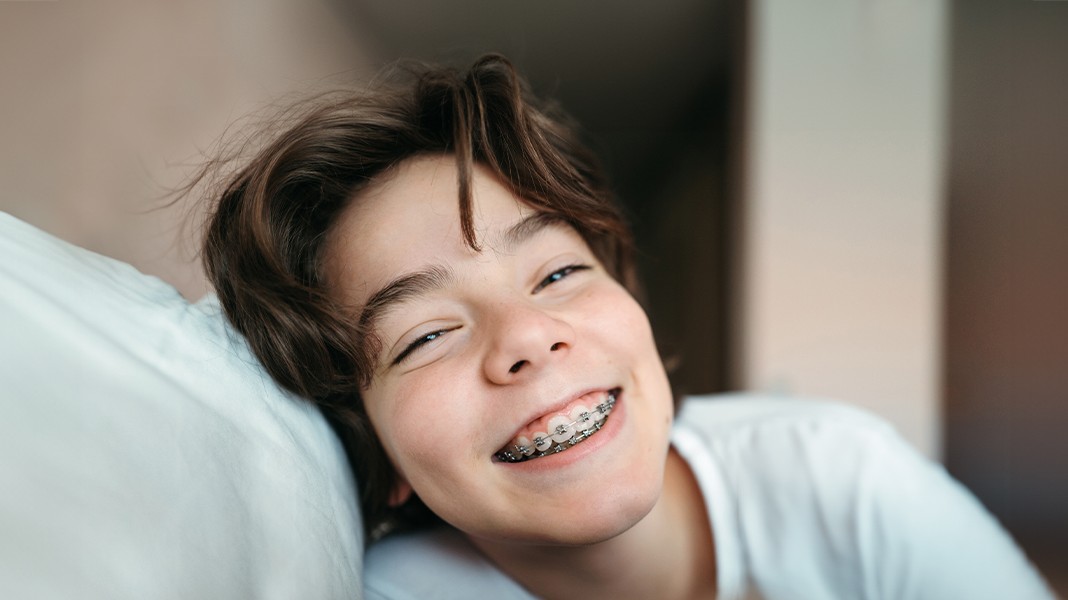 Ein Kind mit Zahnspange grinst in die Kamera