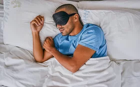 Ein Mann schläft tagsüber mehrmals mit einer Augenmaske.