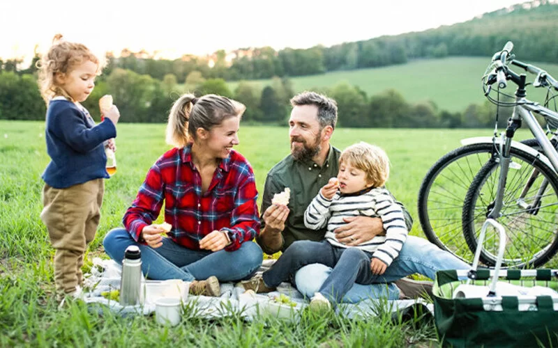 Eine Familie mit zwei Kindern macht eine Picknick-Pause bei ihrer Radtour.