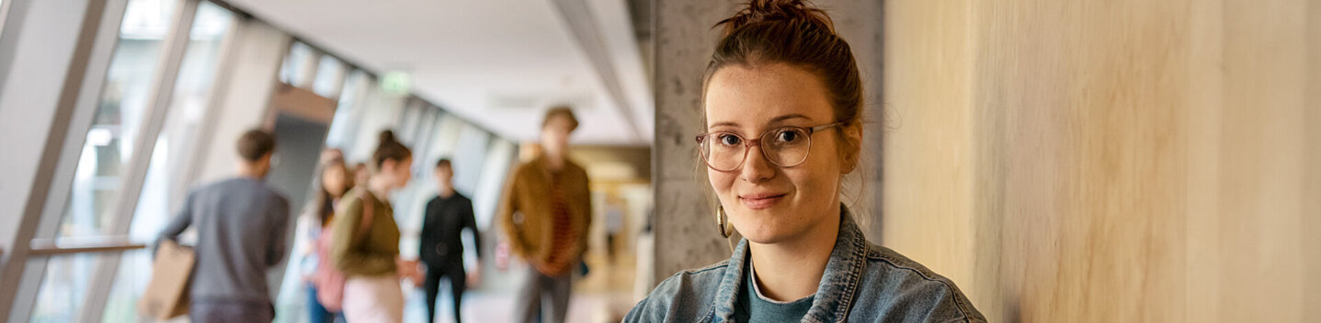Eine Studentin wartet vor einem Hörsaal. Die AOK sorgt beim Auslandsstudium für den Versicherungsschutz.