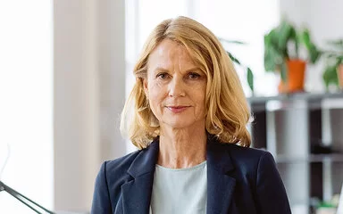 Porträt einer selbstbewussten, reifen Geschäftsfrau, die an einem Schreibtisch im Büro steht.