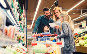 Eine Familie ist gemeinsam einkaufen im Supermarkt.