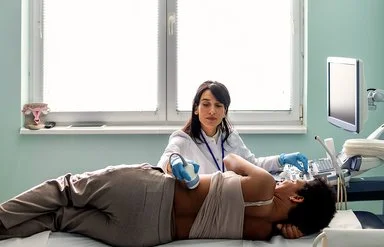 Eine Ärztin macht bei einer jungen Patientin eine Ultraschalluntersuchung der Nieren.