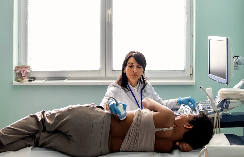 Eine Ärztin macht bei einer jungen Patientin eine Ultraschalluntersuchung der Nieren.