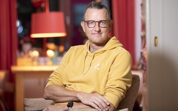 Ulli Hahndorf sitzt und lächelt in die Kamera.