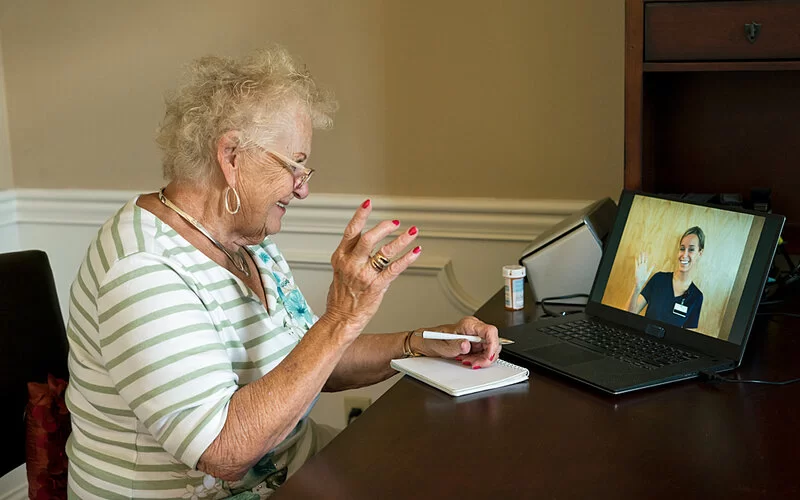 Eine Seniorin ist in einer Videosprechstunde mit einer Ärztin.