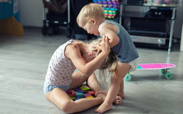 Aggressives Kind schlägt seine Schwester.