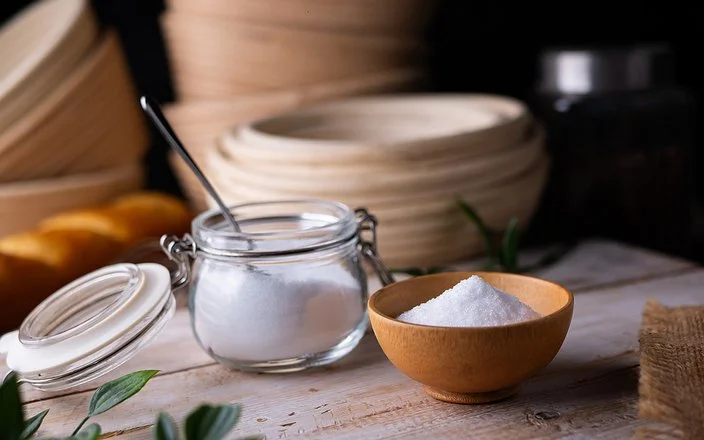 Erythrit, ein Zuckerersatz, in einem kleinen Einmachgläschen auf einem Brett.