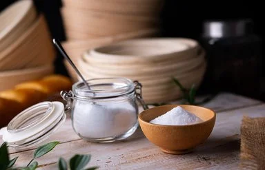 Erythrit, ein Zuckerersatz, in einem kleinen Einmachgläschen auf einem Brett.