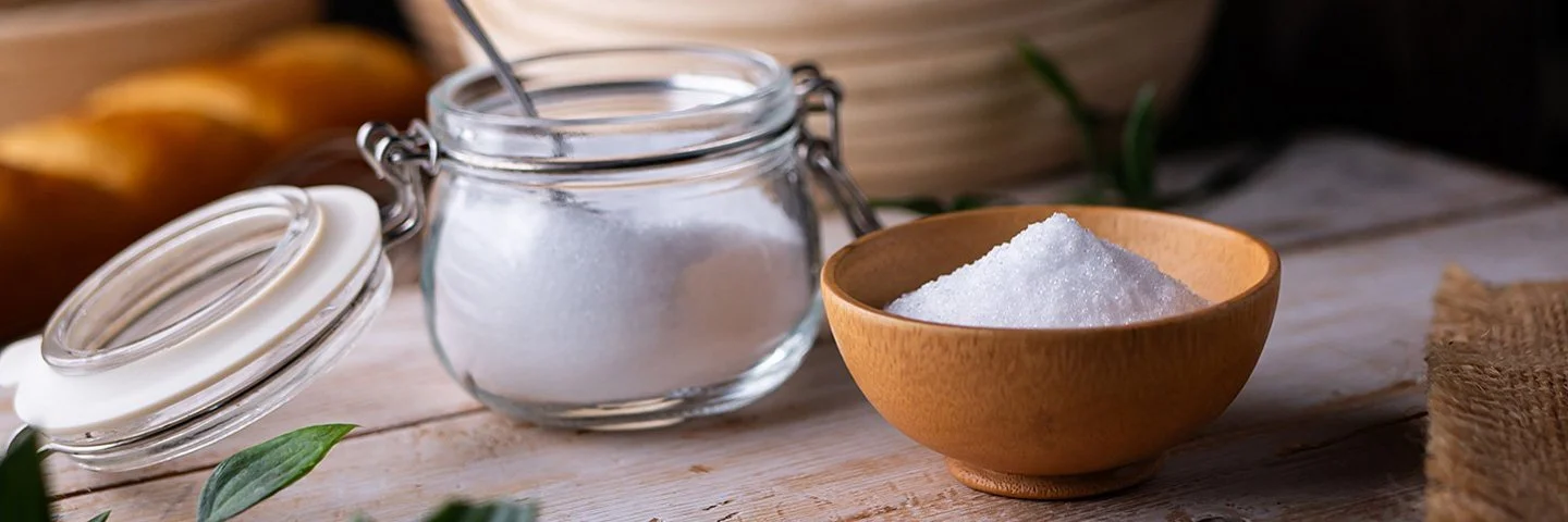 Erythrit, ein Zuckerersatz, in einem kleinen Einmachgläschen auf einem Brett.