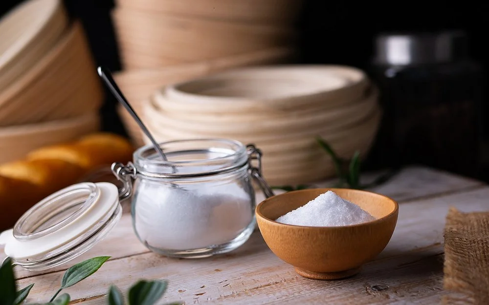 Erythrit, ein Zuckerersatz, in einem kleinen Einmachgläschen auf einem Brett.