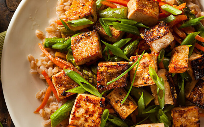Gebratenes Tofu mit Gemüse und Gerste.