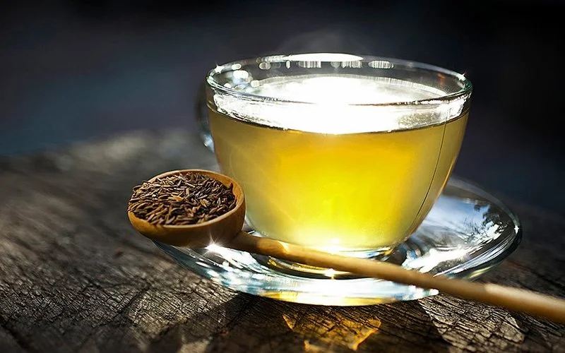 Eine Tasse mit Anistee steht auf einem Holztisch.