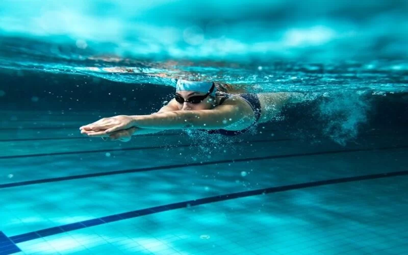 Eine Frau taucht beim Schwimmen unter Wasser.