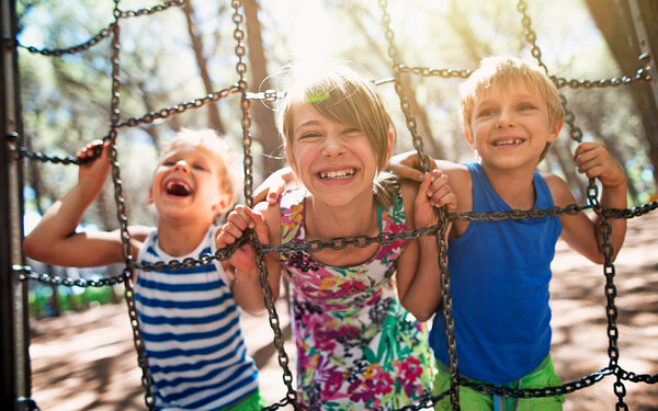 Drei Kinder spielen bei Sonne draußen und tanken Vitamin D, welches der Körper für den Knochenwachstum und gegen die Krankheit Rachitis benötigt.