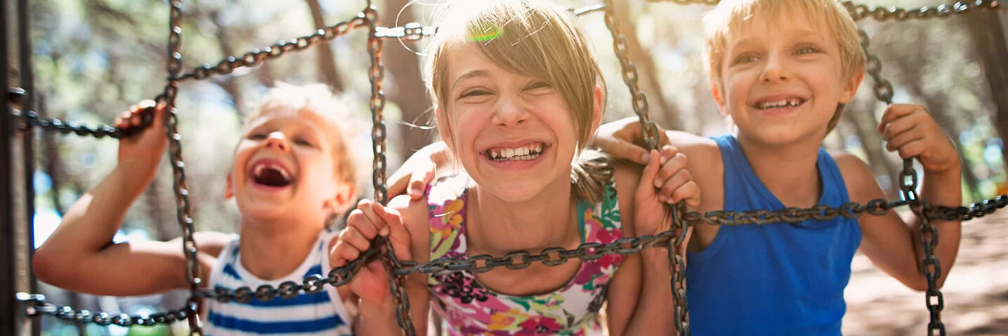 Drei Kinder spielen bei Sonne draußen und tanken Vitamin D, welches der Körper für den Knochenwachstum und gegen die Krankheit Rachitis benötigt.