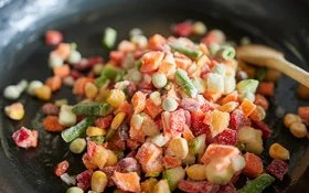 Nahaufnahme von gefrorenem Gemüse in einer Bratpfanne.