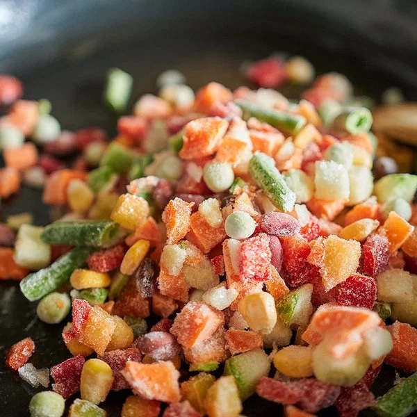 Nahaufnahme von gefrorenem Gemüse in einer Bratpfanne.