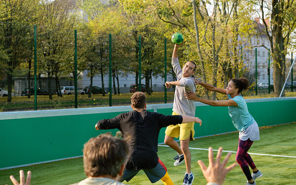 Eine Gruppe junger Menschen spielt Handball.