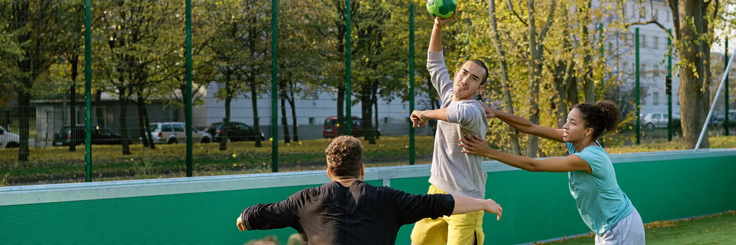 Eine Gruppe junger Menschen spielt Handball.