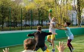 Eine Gruppe junger Menschen spielt Handball.