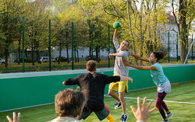 Eine Gruppe junger Menschen spielt Handball.