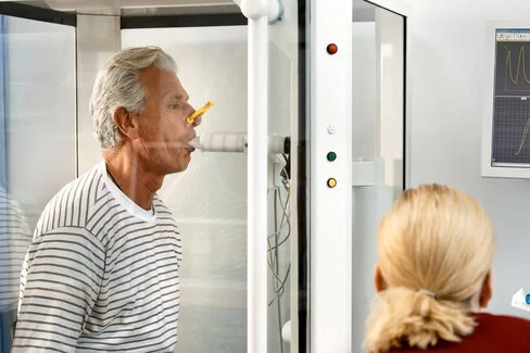 Eine Ärztin misst die Lungenfunktion eines Patienten. Mit dem AOK-Curaplan COPD lernen Erkrankte, ihre Lungenerkrankung zu kontrollieren.