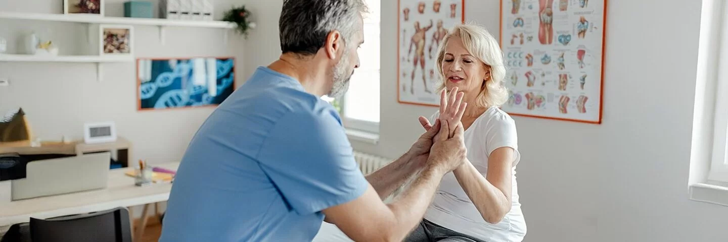 Ein Physiotherapeut bei der Arbeit mit einer älteren Patientinnen in der Klinik