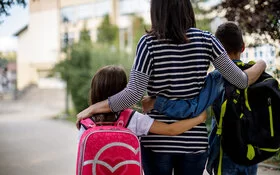 Helikoptereltern: Eine überfürsorgliche Mutter bringt ihre Kinder zur Schule.