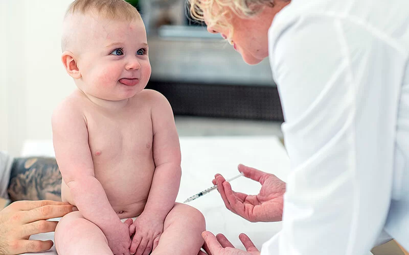 Eine Kinderärztin impft ein Baby gegen Röteln.