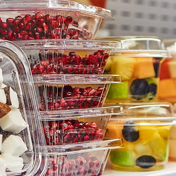 In Plastikbehältern verpacktes Obst, Granatapfelkerne und Kokosnussstücke.
