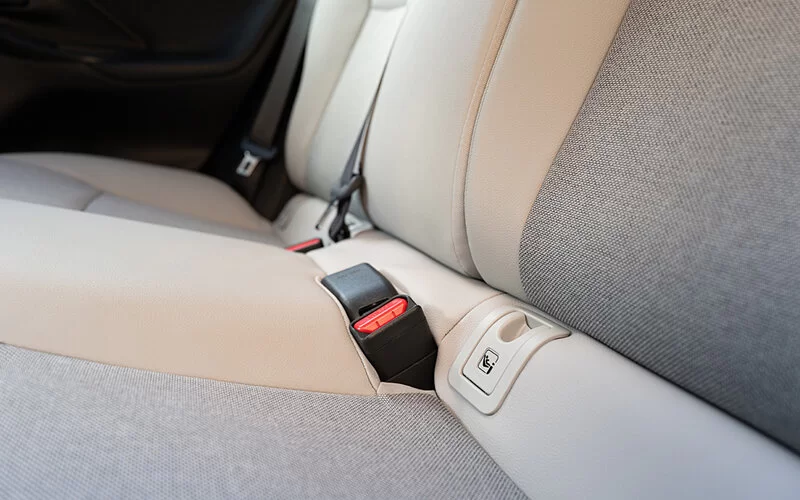 Großaufnahme eines Isofix-Befestigungssystems für Babyschalen und Kindersitze auf einer Auto-Rückbank.