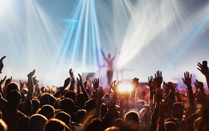 Menschen mit erhobenen Händen bei einem Konzert oder Festival