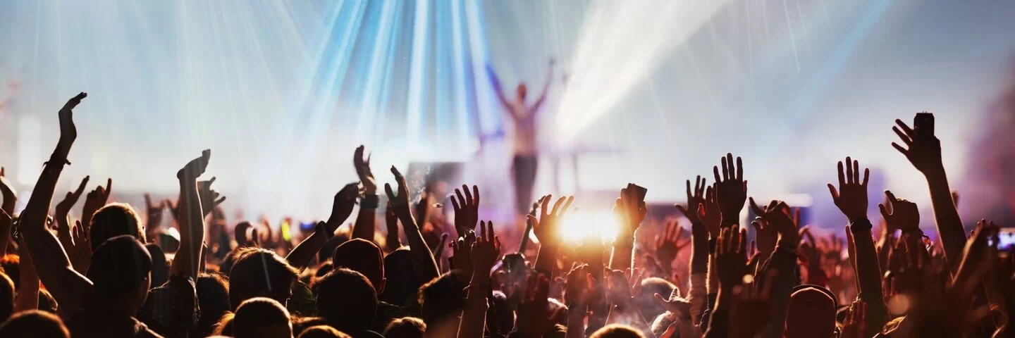 Menschen mit erhobenen Händen bei einem Konzert oder Festival