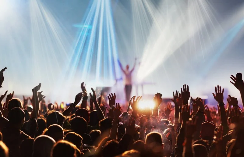 Menschen mit erhobenen Händen bei einem Konzert oder Festival