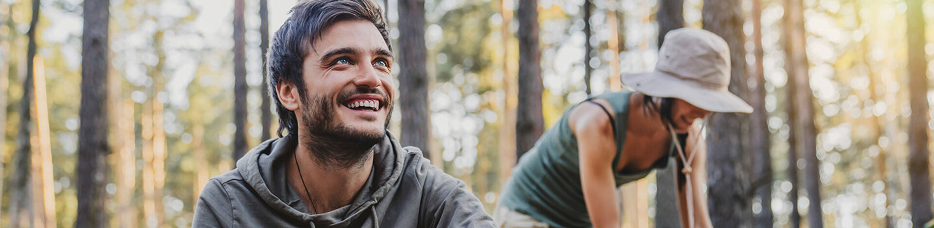 Zwei Menschen sind in der Natur und lachen.