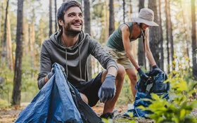 Zwei Menschen sind in der Natur und lachen. 