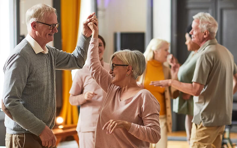 Eine Gruppe von älteren Menschen tanzt gemeinsam.