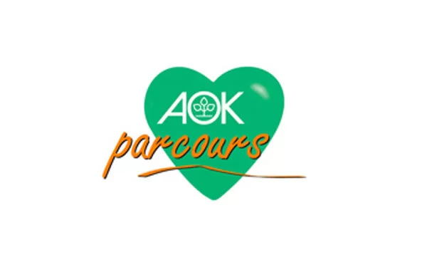 Das Bild zeigt das AOK Parcours Logo. Man sieht ein grünes Herz mit weißem AOK-Schriftzug und das Wort "parcours"in orangenen Buchstaben.