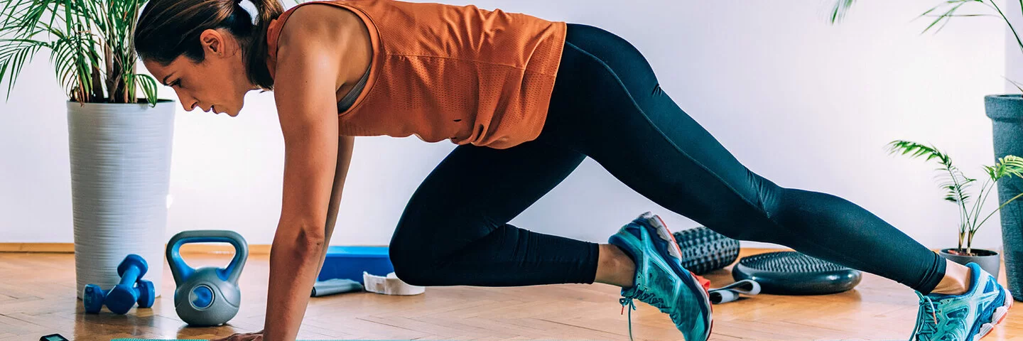 Eine Frau macht Zuhause die Übung Mountain Climber – so gelingt das Cardio Training.